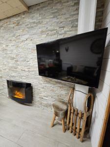 une cheminée avec une télévision et une chaise dans l'établissement Chalet Alpha, aux Angles