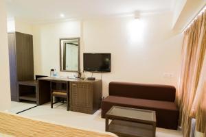 a living room with a couch and a television at Hotel Aroma Executive Panaji -Stay in the Heart of the City in Panaji
