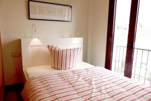 ein Schlafzimmer mit einem Bett mit Kissen und einem Fenster in der Unterkunft La Torrecilla in Castillo Bajo