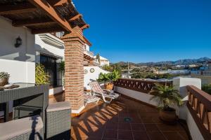 ein Balkon mit Stühlen und einer gemauerten Säule in der Unterkunft La Torrecilla in Castillo Bajo