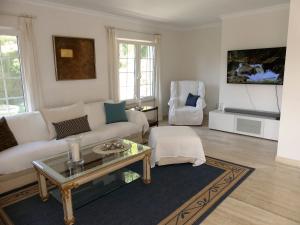 Una sala de estar con un sofá blanco y una mesa. en Casa Jolanda, en La Caleta