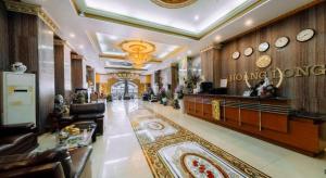 a lobby of a hotel with couches and clocks on the wall at Hoang Long Hotel - Hai Phong City Center in Hai Phong