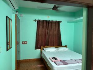 ein Schlafzimmer mit einem Bett mit blauen Wänden und einem Fenster in der Unterkunft Balaji home stay in Puducherry