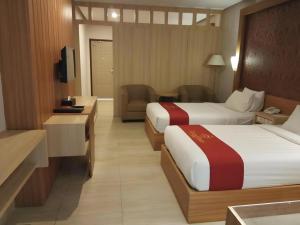 a hotel room with two beds and a television at Grand Dian Hotel Slawi in Procot