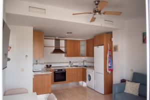 a kitchen with wooden cabinets and a white refrigerator at A & G Sabinillas in San Luis de Sabinillas