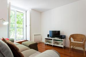 uma sala de estar com um sofá e uma televisão em ALTIDO Belem Burgundy em Lisboa