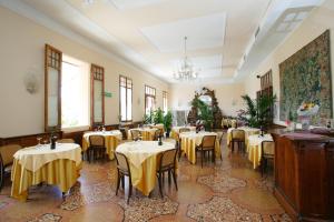 a restaurant with tables and chairs in a room at Hotel Antico Borgo in Riolo Terme