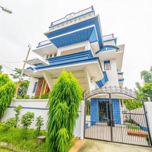a blue and white house with a gate at PeaceWood in kolkata