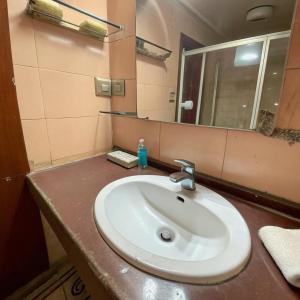 a bathroom with a sink and a mirror at PeaceWood in kolkata +3 photos