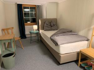 een kleine slaapkamer met een bed en een raam bij DASCO Isenthal in Isenthal