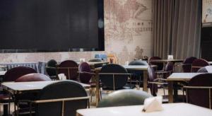 an empty classroom with tables and chairs and a screen at Jinjiang Metropolo Hotel Nanjing Jiangning Binjiang Development Zone in Qingxiu
