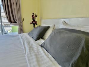 a white bed with two pillows in a bedroom at Baan Keang Talay Cha Am in Cha Am