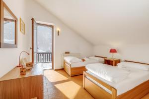 une chambre avec deux lits et un balcon dans l'établissement Appartamento Apapa House - Happy Rentals, à Césane