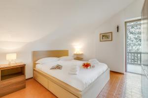 - une chambre avec un grand lit blanc orné de fleurs dans l'établissement Appartamento Apapa House - Happy Rentals, à Césane