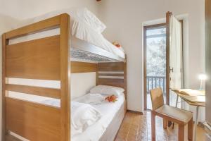 une chambre avec deux lits superposés et un bureau dans l'établissement Appartamento Apapa House - Happy Rentals, à Césane 23 autres photos