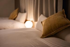 a close up of a bed with a pillow on it at Ojanse博多 in Fukuoka +31 photos