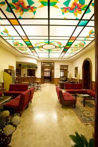 a lobby with a colorful ceiling with chairs and tables at Hotel Antico Borgo in Riolo Terme
