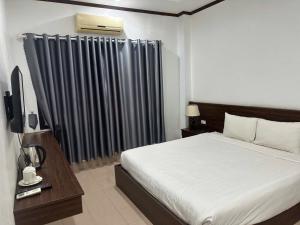 - une chambre avec un lit et un rideau noir dans l'établissement Avenue Hotel VangVieng, à Vang Vieng