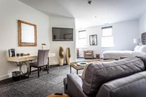 a living room with a bed and a desk and a couch at The Delafield Hotel in Delafield