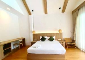 Un dormitorio con una cama blanca en una habitación. en The Poom Cafe & Resort Khao Yai, en Ban Khanong Phra Klang (1)