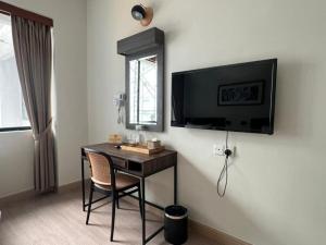 a room with a desk with a television on the wall at Swing & Pillows - I-City, Shah Alam in Klang