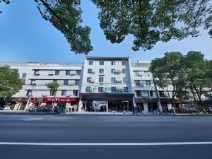 a large white building on the side of a street at Magnotel Business Shanghai Minhang Wujing East China Normal University in Shanghai