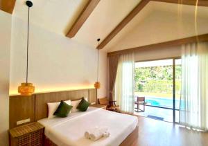 a bedroom with a large white bed and a pool at The Poom Cafe & Resort Khao Yai in Ban Khanong Phra Klang (1)