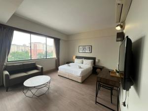 a hotel room with a bed and a tv and a couch at Swing & Pillows - I-City, Shah Alam in Klang
