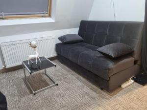 a living room with a couch and a table with a statue at Garsoniera Luxury central 2 in Craiova