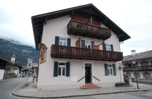 加尔米施-帕滕基兴Höllental heritage House - BergPANORAMA - 5的街道上一栋带阳台的白色建筑