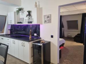 a kitchen with a sink and a purple counter top at Garsoniera Luxury central 2 in Craiova