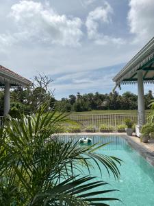a swimming pool in a yard with a fence at ISOLA - Surf House in Koggala