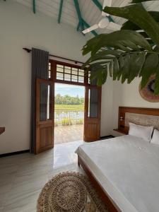 a bedroom with a bed and a sliding glass door at ISOLA - Surf House in Koggala