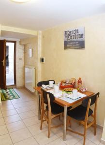 comedor con mesa de madera y sillas en La casetta dei Desideri, en Poggio Bustone