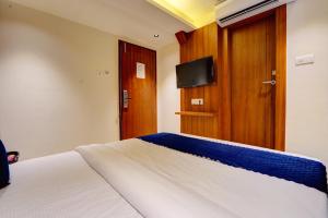 a bedroom with a bed with a tv on the wall at Hotel Isra Comfort Inn in Mumbai