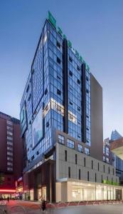a tall building with a sign on top of it at ibis Styles Kunming Nanping Hotel in Kunming