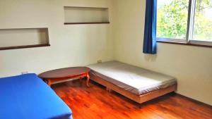 Ένα ή περισσότερα κρεβάτια σε δωμάτιο στο リリコイハウス真栄里