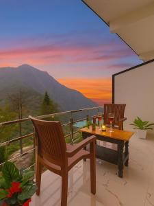 uma mesa e cadeiras em uma varanda com vista em Hotel The SSB - ! luxury balcony rooms ! mountain view ! rooftop cafe ! big parking ! property of the year ! em Mussoorie
