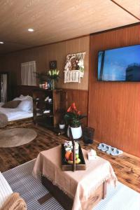 a living room with a table and a tv on the wall at Xing Retreat & Spa Măng Đen in Kon Plong +42 photos