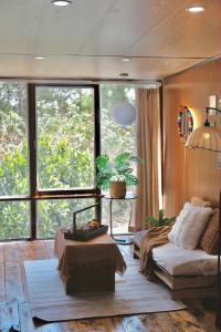 a living room with a couch and a large window at Xing Retreat & Spa Măng Đen in Kon Plong