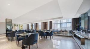 een restaurant met tafels en stoelen in een gebouw bij Jinjiang Inn Select Taizhou Jiangyan Coach Terminal in Magou