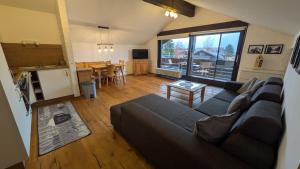 een woonkamer met een bank en een tafel bij Ferienwohnung Alpenhorn in Bolsterlang Sommerbergbahn kostenlos in Bolsterlang