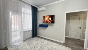 a living room with a fire on the wall at Athletic City, 1-Room Apartments in Taldykolʼ
