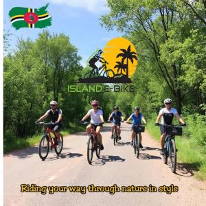 a group of people riding bikes down a dirt road at S&D Beauty Home in Roseau