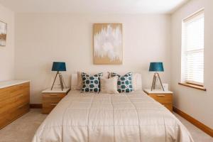 LambegにあるTobela House, Sleeps 10, Ultra Luxuryのベッドルーム1室(大型ベッド1台、ランプ2つ付)