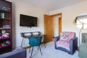 LambegにあるTobela House, Sleeps 10, Ultra Luxuryのリビングルーム(テレビ、椅子付)