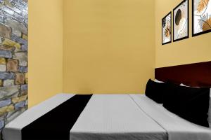 Un dormitorio con una cama y una pared de piedra. en Hotel O Madhyamgram Railway Junction Formerly Dreamland, en Dohāri