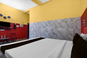 Un dormitorio con una cama y una pared de piedra. en Hotel O Madhyamgram Railway Junction Formerly Dreamland, en Dohāri