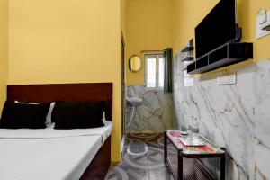 Una pequeña habitación con una cama y un lavabo. en Hotel O Madhyamgram Railway Junction Formerly Dreamland, en Dohāri 22 fotos más