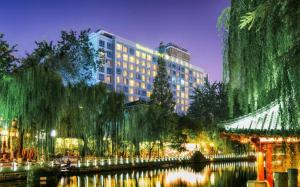 een weergave van een groot gebouw naast een rivier bij Jinan Silver Plaza Quancheng Hotel in Jinan